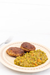 Served fried meatballs with cooked peas on the plate