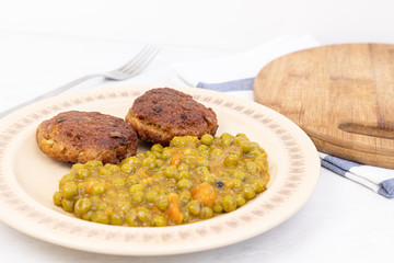 Served fried meatballs with cooked peas on the plate