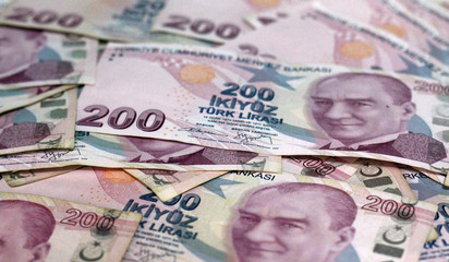 American dollar banknotes and Turksh Lira banknotes side by side on white background.