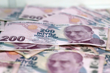 American dollar banknotes and Turksh Lira banknotes side by side on white background.