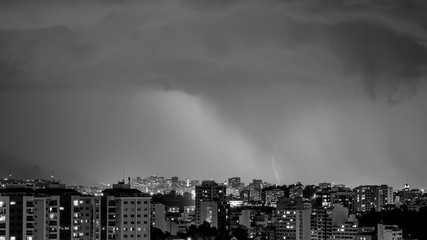 Imagens da chegada de uma tempestade de verão com raios e chuva, na cidade durante a noite em...