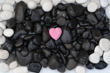 a lonesome hearth on stones of black and white pebbles with water drops. abstract background, spa