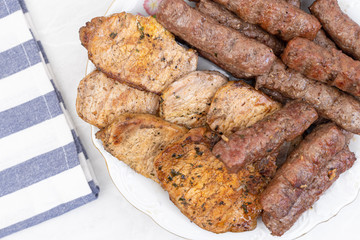 Mixed grilled meat on the plate. Grilled kebabs and pork chops served on the plate