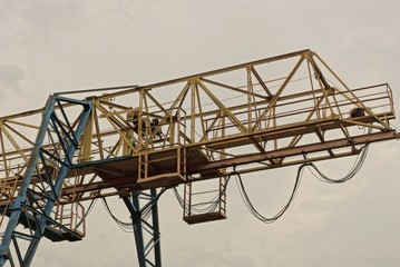 part of a yellow iron industrial crane jib on a gray sky background