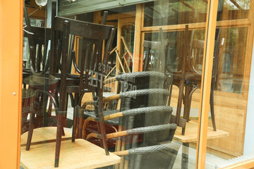 Rattan chairs stacked outside a bistro in paris, France