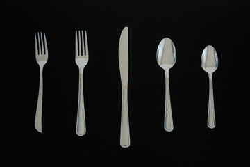 Top view of a silverware placed on a dark table