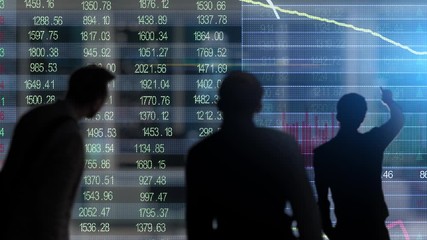 multiple people looking at stock market graphs - Powered by Adobe