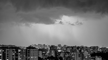 Imagens da chegada de uma tempestade de verão com raios e chuva, na cidade durante a noite em...