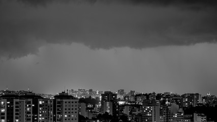 Imagens da chegada de uma tempestade de verão com raios e chuva, na cidade durante a noite em...