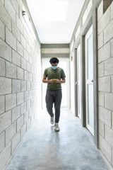 Young man with mouth mask alone in building under construction.