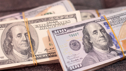 Stack of one hundred dollar bills close-up.
American dollars in one hundred banknotes.