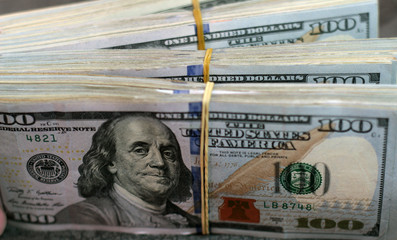 Stack of one hundred dollar bills close-up.
American dollars in one hundred banknotes.