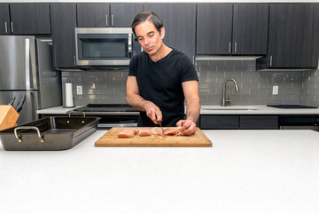 Prepping raw chicken breast for baking
