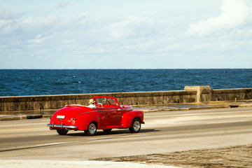 Red car on the road to the pier in Havana Cuba
