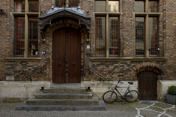 Fototapeta na wymiar Detail of wooden door and brick facade with bicycle