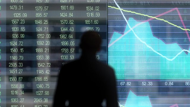 man looking at stock market graph on screen