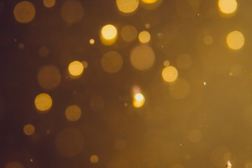 Dark Abstract Gold bokeh sparkle on black background