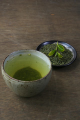Japanese green tea in a bowl on a dark wooden table 