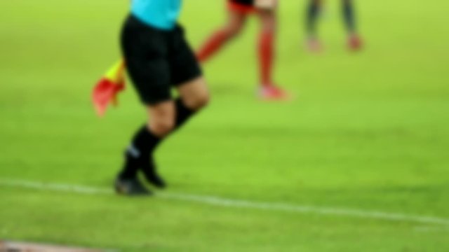 Scene defocused slow motion of assistant referees in action during a soccer match