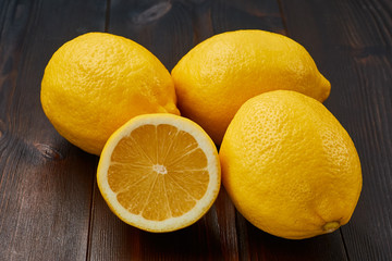 Group of fresh juicy lemons on a dark wooden table