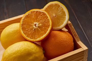 Box with bright juicy oranges and lemons.