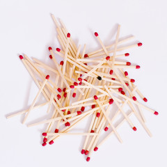 pile of matches on a white background with a single burnt match