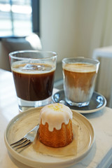 Lemon cake served with a glass of Latte and black coffee