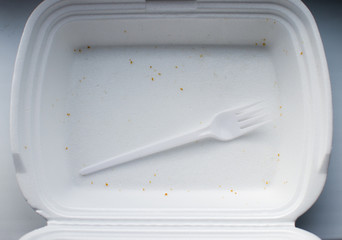 plastic fork in empty white foam box for food. view from above