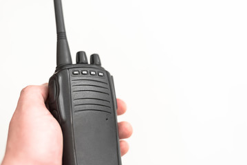 The young man is holding a radio transmitter in his hand on a white background. Walkie-talkie.