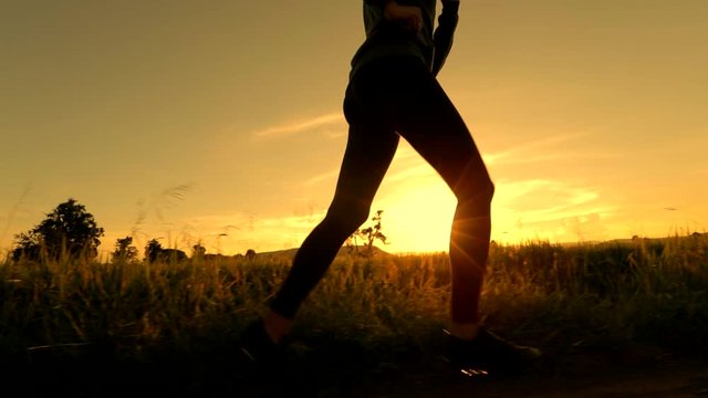 Scene slow motion silhouette of woman running near the meadow in the morning, Concept of woman exercising and healthy