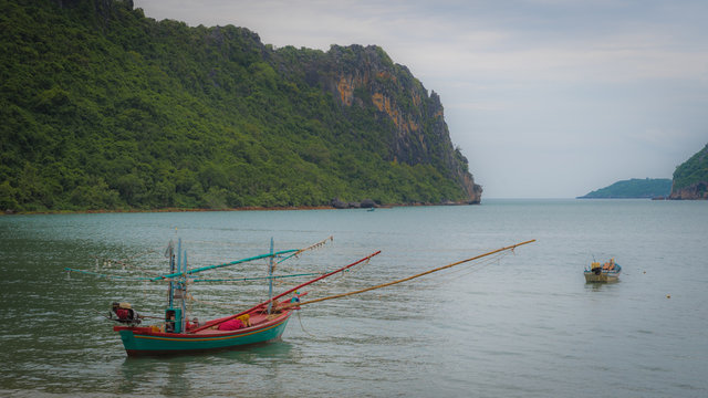 Traditional Thail fishing boat with reflection at mooring in the sea