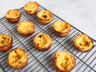 Fresh baked Portuguese Egg Custard Tarts, Pasteis De Nata, on a cooling rack 