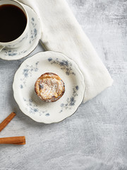 Fresh baked Portuguese Egg Custard Tarts, Pasteis De Nata, served on a vintage porcelain plate with a cup of hot coffee. 