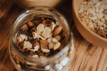 Mix of dried fruits and nuts in a glass jar on a wooden background. The concept of a healthy diet and healthy lifestyle.