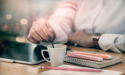 Businesswoman with cup of coffee in cafe.