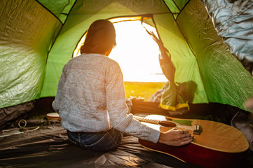 The woman asian who just woke up inside the tent was watching the sunrise in the morning as a...