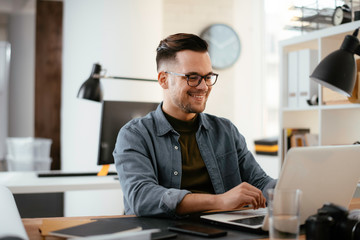 Businessman in office. Handsome man working on lap top.