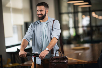 Young man on e-scooter. Businessman driving electric scooter in office.	