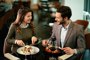 Happy loving couple enjoying in restaurant. Young couple enjoying in food.	