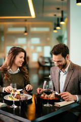 Happy loving couple enjoying in restaurant. Young couple enjoying in food.	