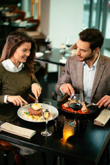 Happy loving couple enjoying in restaurant. Young couple enjoying in food.	
