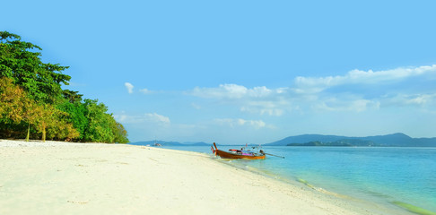 Fototapeta premium beautiful tropical landscape. Thai traditional longtail boat and sandy beach. Summer travel and sea trip vacation. copy space.