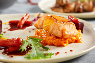 Salmon fillet with beet in herbs and passion fruit sauce close up