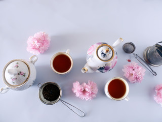 Obraz na płótnie Canvas Tea set, cups with tea and pink flowers