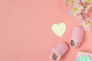 Top view aerial image of decoration Happy mothers day holiday background concept.Flat lay baby shoes and heart shape on modern beautiful pink paper at home office desk.pastel tone creative design.