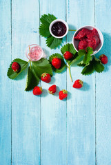 strawberry fruits with jelly, jam, marmalade on old blue table