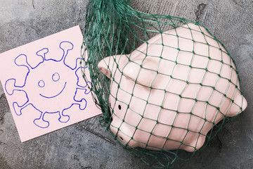 Piggy bank in a grid and tag with text, top view. The concept of the lack of money in people due to coronavirus