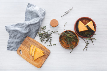 Tasty cheese with thyme on white wooden table