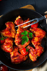 Spicy chicken wings in honey with potato wedges