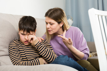 Mother and  offended son crying during  arguing in domestic interior